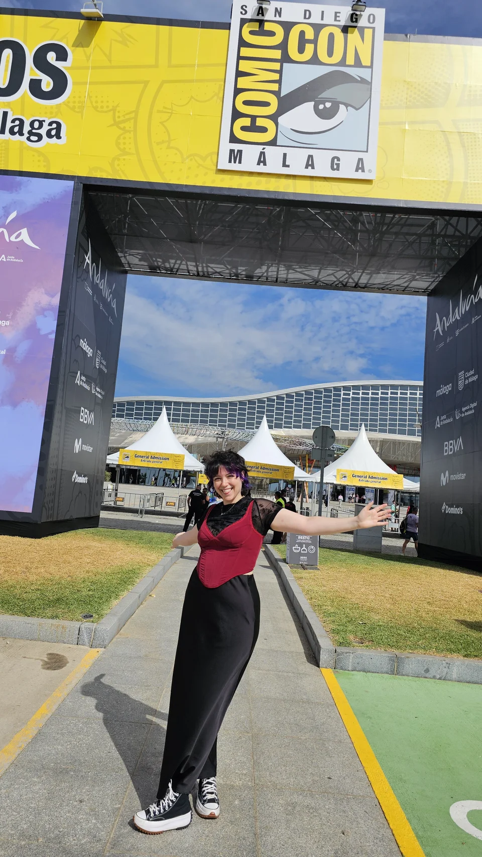 Sara sonriendo con los brazos abiertos en la entrada de Comic-Con Málaga