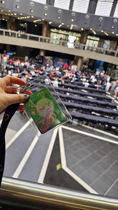Token Sprite de Sara en una funda rígida, sostenido ante las mesas del encuentro en Murcia